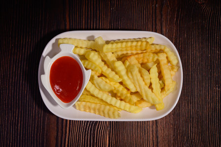 French fries with ketchup on wooden background. Top view. Toned.の写真素材