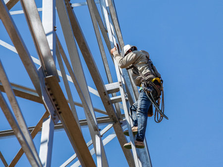 worker climbing on transmission line tower