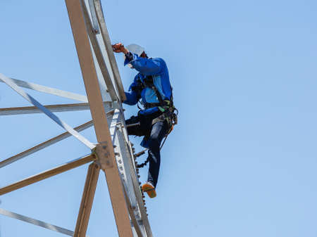worker climbing on transmission line towerの写真素材