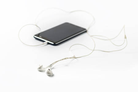 Smartphone with earphones on white backgroundの写真素材