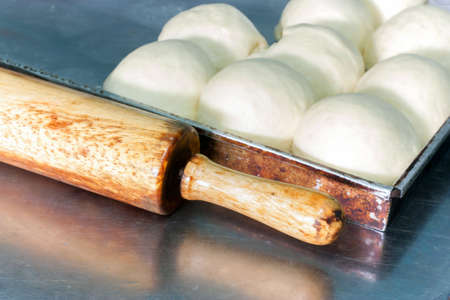 ball of dough and rolling pin on tableの写真素材