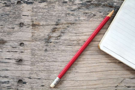 note book pencil on old wood tableの写真素材