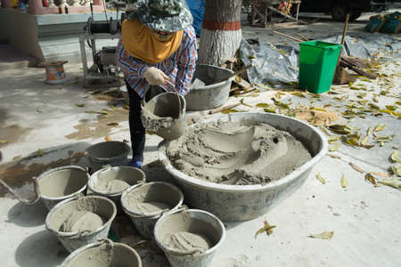Construction workers mixing mortarの写真素材