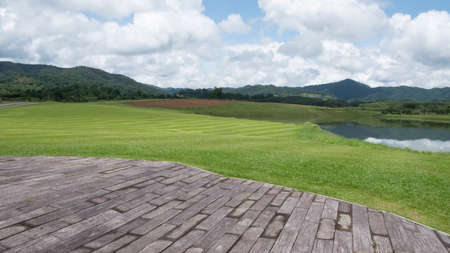 Wood old table against landscape mountain and cloud sky background with focus to the table top in the foregroundの写真素材
