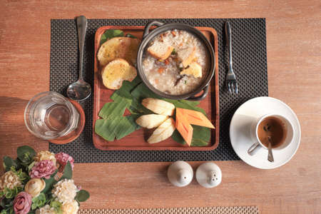 Breakfast set consists of mushroom soup, bread and fruit.の写真素材