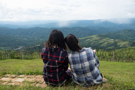 Friendship between friends. Two women sitting at the viewの写真素材