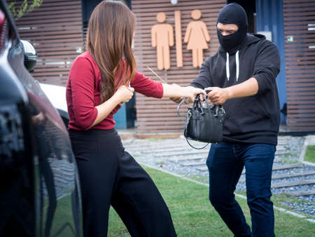 Black robbers are robbing women.の写真素材