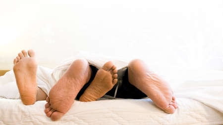couple feet on bedの写真素材