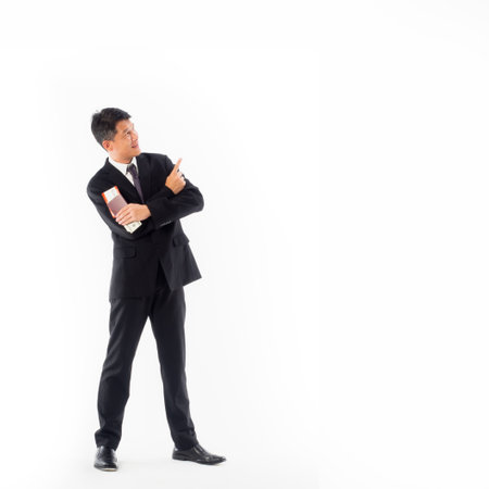 Smiling asia businessman standing with passport on whiteの写真素材