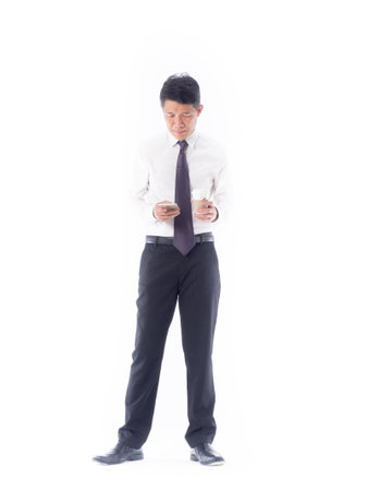 A businessman holding smartphone and cup of coffee on whiteの写真素材