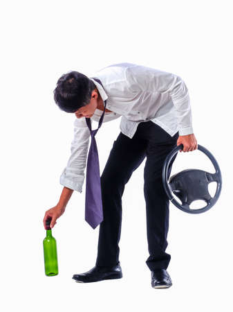 drunk business man wear black suit holding wine bottle and steering wheel on  isolated white backgroundの写真素材
