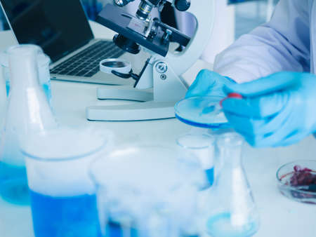 cluse up scientist wear rubber gloves dropping blue liquid biology chemical test in laboraty.の写真素材