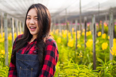 beauty asia farmer woman gardener of orchid gardening farm collection the orchids flower.Business owner garden farm  checking blooming in the garden.の写真素材