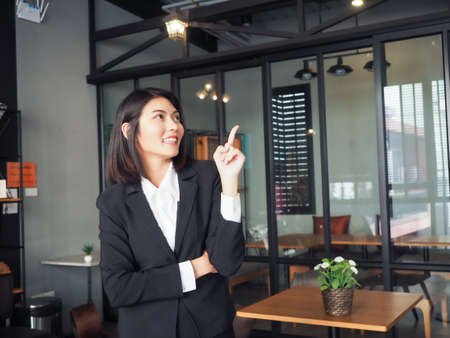 asia business man woman standing cross arm and pointing,thumbs up,looking camera copy spaceの写真素材