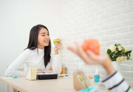 asian beauty woman holding apple. smiley face female eating apple organic fruit in house with copy space.の写真素材