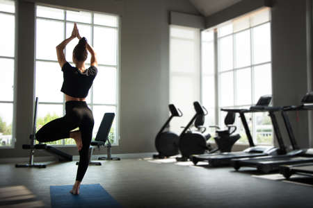 Beautiful caucasion white woman doing yoga exercises in fitness gym.の写真素材