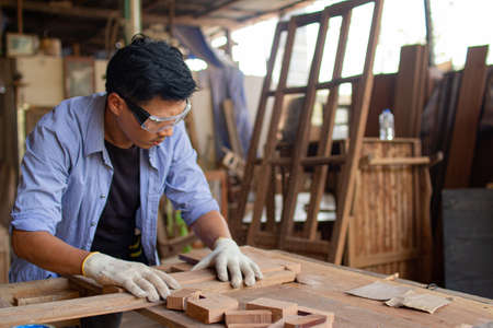 Two asian carpenters in a construction workshop. business man and woman working together woodworkの写真素材