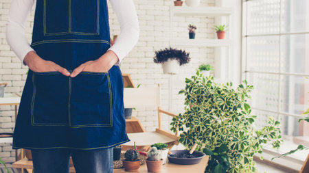 close up entreprenrur man wearing apron standing with indoor gardenの写真素材
