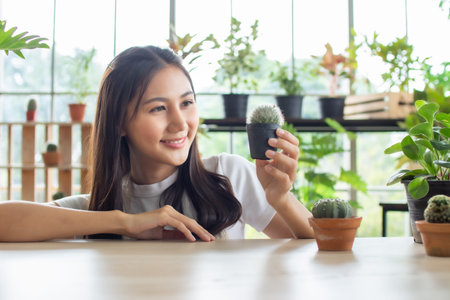 close up asia beauty Woman Holding Potted Cactus succculent plants at home