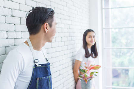 asia entrepreneur beauty woman sitting and holding plant in indoor garden.smiley face gardener wearing apron in plants shopの写真素材