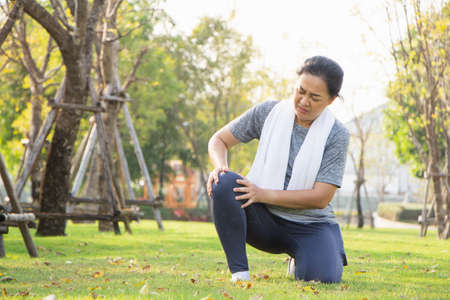 Old Asian people suffer from exercise pain. old woman suffering from a sore knee.の写真素材