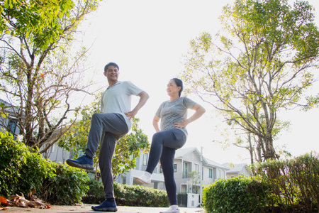 A couple of older Asian men and women wear exercise clothes before their morning exercises.