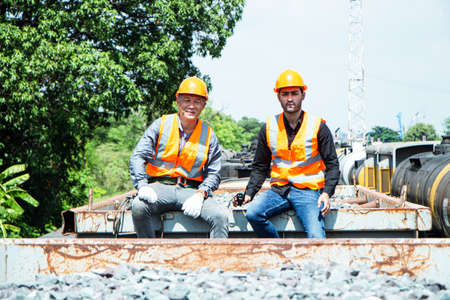 Inspector Engineering wearing helmet and vest worker unifrom checking railway construction work on rail track. Asian worker and coworker on rock wool bogieの写真素材