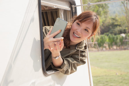 backpack solo female tourist having a happy summer vacation camping car in the morning