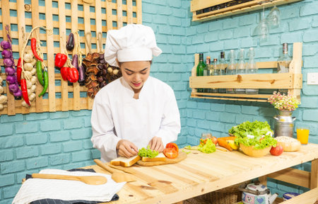 Asian woman in chef's uniform is cooking in the kitchen