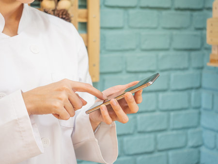 Asian woman in chef's uniform is cooking in the kitchen
