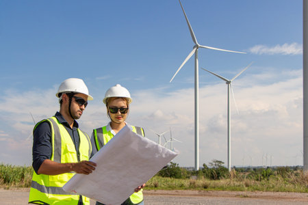 engineer team working in wind turbine farm. Renewable energy with wind generator by alternative...