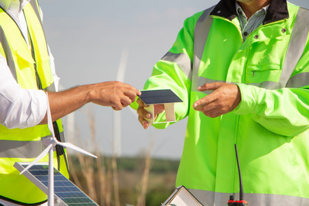 engineer team working in wind turbine farm and solar cell. Renewable energy with wind generator by...