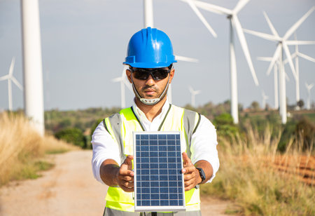 engineer team working in wind turbine farm and solar cell. Renewable energy with wind generator by...