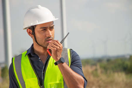engineer team working in wind turbine farm. Renewable energy with wind generator by alternative energy concept. engineering stood with his arms crossed and looked at the camera.の写真素材