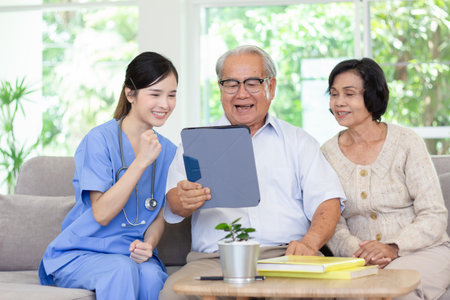 Nursing Home Care concept. Beautiful Asian nurse and elderly person using tablet video call online Chatting with family while in nursing home.の素材 [FY310198902912]