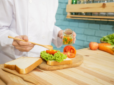 Asian woman in chef's uniform is cooking in the kitchenの写真素材