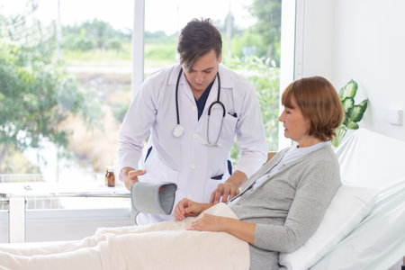 Doctor measuring blood pressure of pregnant woman in ward at hospital or medical clinicの写真素材