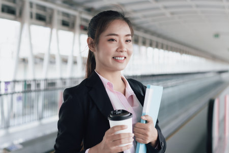 business woman with coffee to go in train station, business travel conceptの写真素材