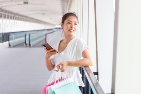 Young woman walking with shopping bags in the city. Shopping concept.の写真素材