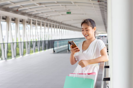 Young woman walking with shopping bags in the city. Shopping concept.の写真素材