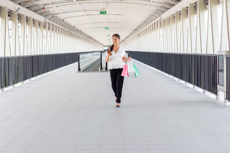 Young woman walking with shopping bags in the city. Shopping concept.の写真素材