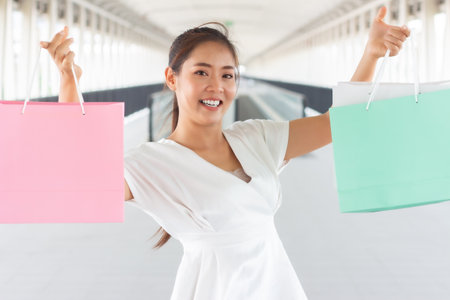 Young woman walking with shopping bags in the city. Shopping concept.の写真素材