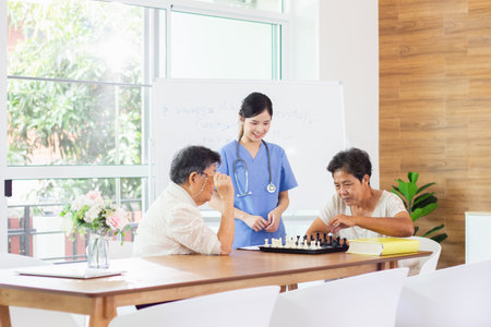 Asian female doctor and senior couple playing chess in the meeting room.の写真素材