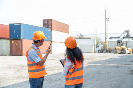 Portrait of Asian engineer and worker working with co-worker at overseas shipping container yard.の写真素材