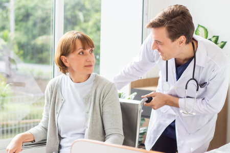 Doctor and senior woman patient discussing something while sitting at the table. Medicine and health care concept.の写真素材