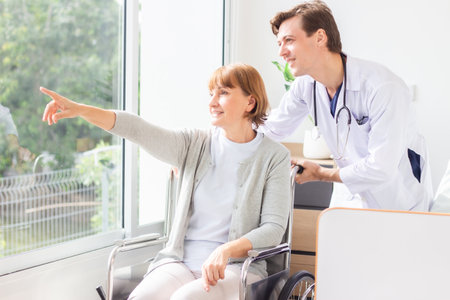 Doctor and senior patient in wheelchair at hospital. Medical and healthcare concept.の写真素材