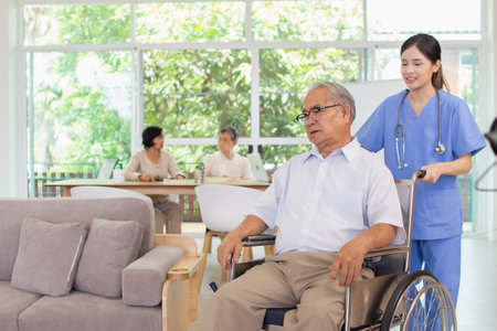 asian senior man in wheelchair with nurse in nursing home or nursing homeの写真素材