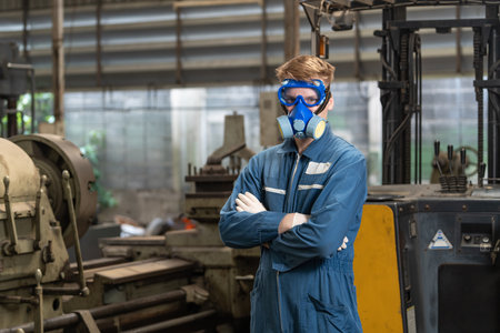 emergency pollution factory concept. Portrait engineer wearing a mechanical jumpsuit and gas mask looking at the camera with his arms crossed.の写真素材