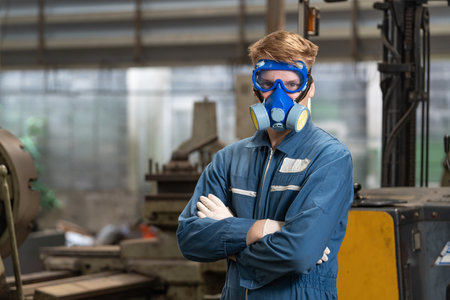 emergency pollution factory concept. Portrait engineer wearing a mechanical jumpsuit and gas mask looking at the camera with his arms crossed.の写真素材