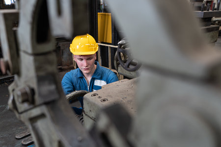 Portrait of a young male worker in a hardhat at a factoryの写真素材